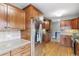 Updated kitchen with stainless steel refrigerator, hardwood floors, tiled backsplash, and brick accent wall at 3055 N Albion St, Denver, CO 80207
