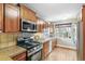 This kitchen has a gas range, wood cabinets, stainless appliances, and a large window bringing in natural light at 3055 N Albion St, Denver, CO 80207