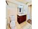 Bathroom with tiled floor, wooden vanity, three-light vanity lighting, mirror and toilet at 605 S Alton Way # 7A, Denver, CO 80247