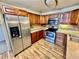 View of the kitchen featuring stainless steel appliances, wood cabinets, and laminate flooring at 605 S Alton Way # 7A, Denver, CO 80247