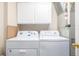 The laundry room has a white washer and dryer, and white cabinets at 1747 N Washington St # C306, Denver, CO 80203