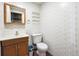 Cozy bathroom with sink, mirror, toilet, and shelving, perfect for a functional and tidy space at 11418 Macon St, Commerce City, CO 80640
