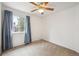 This bedroom features plush carpeting, a window for natural light, and a ceiling fan at 11418 Macon St, Commerce City, CO 80640