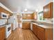Functional kitchen with wooden cabinets, appliances, and adjacent dining area at 11418 Macon St, Commerce City, CO 80640