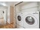 Conveniently located laundry room with modern washer and dryer units and shelving for storage at 11418 Macon St, Commerce City, CO 80640
