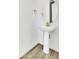 Chic powder room features a pedestal sink, round mirror, and modern fixtures at 9022 Spaulding St, Parker, CO 80134