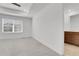 Bright, carpeted bedroom with tray ceiling, ceiling fan, and an attached bathroom at 9022 Spaulding St, Parker, CO 80134