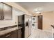 Kitchen featuring stainless steel refrigerator and washer and dryer, with stone countertop and backsplash at 11937 E Harvard Ave # 102, Aurora, CO 80014