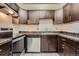 Kitchen features stainless steel appliances and dark wood cabinetry and stone countertops at 11937 E Harvard Ave # 102, Aurora, CO 80014