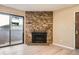 Bright living room featuring a stone fireplace and sliding glass door access to the balcony at 11937 E Harvard Ave # 102, Aurora, CO 80014