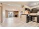 Open living room featuring a stone fireplace, balcony access, and modern kitchen with stainless steel appliances at 11937 E Harvard Ave # 102, Aurora, CO 80014