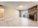 Inviting living room with a stone fireplace, neutral walls, and light wood floors at 11937 E Harvard Ave # 102, Aurora, CO 80014