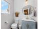 Stylish powder room featuring a blue vanity, modern fixtures, and shiplap accent wall at 14836 Jersey Dr, Mead, CO 80542