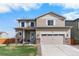 Charming two-story home features a stone-accented facade, attached garage, and well-maintained lawn at 14836 Jersey Dr, Mead, CO 80542