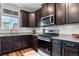 Modern kitchen featuring dark cabinets, stainless steel appliances, and stylish countertops at 14836 Jersey Dr, Mead, CO 80542