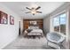 Spacious main bedroom with wood accent wall, ceiling fan, and large window at 14836 Jersey Dr, Mead, CO 80542