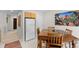 Dining area with a large refrigerator and wood table with seating, enhanced by a nature-themed artwork at 4023 E Geddes Cir, Centennial, CO 80122