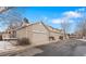 Exterior view of townhomes with attached garages and neutral color scheme against a blue sky at 4023 E Geddes Cir, Centennial, CO 80122