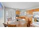 Bright kitchen features wooden cabinets, white appliances, and a dining area with a wooden table at 4023 E Geddes Cir, Centennial, CO 80122