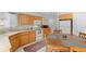 Sunlit kitchen boasts wooden cabinets, white appliances, a wooden dining table and a patterned rug at 4023 E Geddes Cir, Centennial, CO 80122
