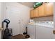 Functional laundry room equipped with a washer, dryer, and storage cabinets at 4023 E Geddes Cir, Centennial, CO 80122