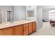 Bright bathroom boasts a double vanity with wooden cabinets, and views into the main bedroom at 4023 E Geddes Cir, Centennial, CO 80122
