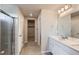 Bright bathroom featuring double vanity, shower, and access to the walk-in closet at 17467 E 89Th Way, Commerce City, CO 80022