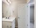 Bright bathroom featuring a white vanity with a quartz countertop and a door to another room at 17467 E 89Th Way, Commerce City, CO 80022