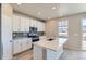Modern kitchen featuring a kitchen island, stainless steel appliances, and white cabinets at 17467 E 89Th Way, Commerce City, CO 80022