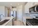 Modern kitchen with stainless steel appliances, an island, and white cabinetry at 17467 E 89Th Way, Commerce City, CO 80022