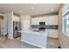 Bright kitchen featuring stainless steel appliances, an island, and white cabinetry at 17467 E 89Th Way, Commerce City, CO 80022