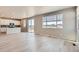 Open concept living room with modern floors, natural light, and a view into the kitchen at 17467 E 89Th Way, Commerce City, CO 80022