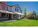 Exterior view of home featuring a covered patio, large windows, and a well-maintained lawn at 9445 Aspen Hill Cir, Lone Tree, CO 80124