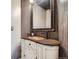 Chic bathroom with granite countertop vanity, dark wood accent wall, and decorative mirror at 9445 Aspen Hill Cir, Lone Tree, CO 80124