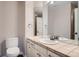 Bathroom with a toilet, large mirror, single sink vanity, and neutral color scheme for a clean look at 9445 Aspen Hill Cir, Lone Tree, CO 80124