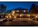Stunning two-story stucco home with stone accents, three-car garage and inviting curb appeal at twilight at 9445 Aspen Hill Cir, Lone Tree, CO 80124