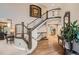Grand foyer showcasing a curved staircase with iron railings and hardwood floors at 9445 Aspen Hill Cir, Lone Tree, CO 80124