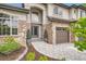 Elegant front entrance with stone accents, decorative plants, and a paved walkway at 9445 Aspen Hill Cir, Lone Tree, CO 80124
