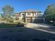 Charming two-story home featuring a stone and stucco facade, manicured lawn, and a three-car garage at 9445 Aspen Hill Cir, Lone Tree, CO 80124