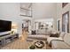 Open-concept living room leading to kitchen and staircase with balcony at 9445 Aspen Hill Cir, Lone Tree, CO 80124