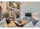 Cozy living room showcasing a stone fireplace, built-in bar, hardwood floors and comfortable seating at 9445 Aspen Hill Cir, Lone Tree, CO 80124