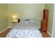 A light green bedroom featuring wood floors and flowered bedding at 95 S Eagle Cir, Aurora, CO 80012