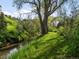 Lush backyard featuring a stream, mature trees, and a well-maintained lawn at 11900 W 18Th Ave, Lakewood, CO 80215