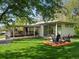 A modern home features a lush backyard with a fire pit and covered patio, seamlessly blending indoor and outdoor living spaces at 11900 W 18Th Ave, Lakewood, CO 80215
