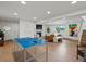 Open basement with a ping pong table, fire place, and comfortable seating area at 11900 W 18Th Ave, Lakewood, CO 80215