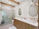 Modern bathroom features dual sinks, sleek countertops, and a glass-enclosed shower with gold hardware at 11900 W 18Th Ave, Lakewood, CO 80215