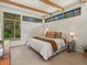Bright bedroom featuring beam ceiling, with large windows and view of exterior greenery at 11900 W 18Th Ave, Lakewood, CO 80215