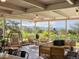 A serene covered patio is furnished with comfortable seating, offering stunning views of lush greenery and distant mountains at 11900 W 18Th Ave, Lakewood, CO 80215