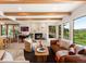 Inviting living room boasting a cozy fireplace, exposed wood beams, and large windows with scenic views at 11900 W 18Th Ave, Lakewood, CO 80215