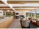 Open-concept living room featuring wood beams, fireplace, and sliding doors to the backyard at 11900 W 18Th Ave, Lakewood, CO 80215